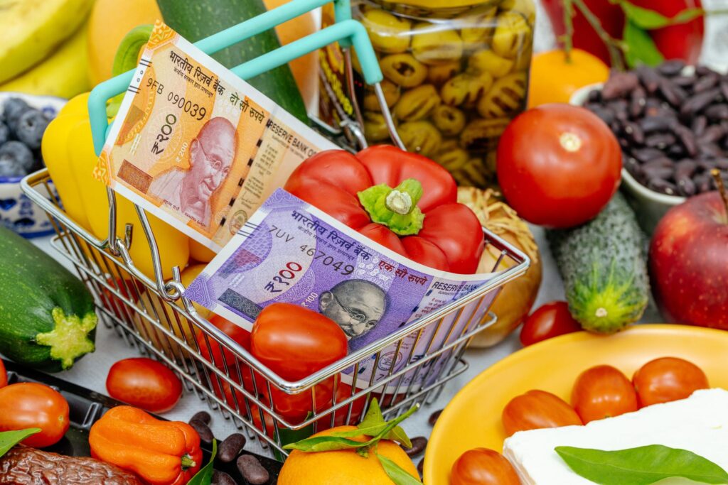 Indian rupee notes in shopping cart with vegetables representing inflation and global economic impact on India